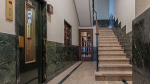 A marble-floored hallway with a staircase leading to a second floor.