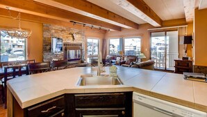 A spacious kitchen with a large island, built-in appliances, and a stone accent wall. - Crested Butte Mountain Resort Properties by Vail Resorts (Crested Butte)