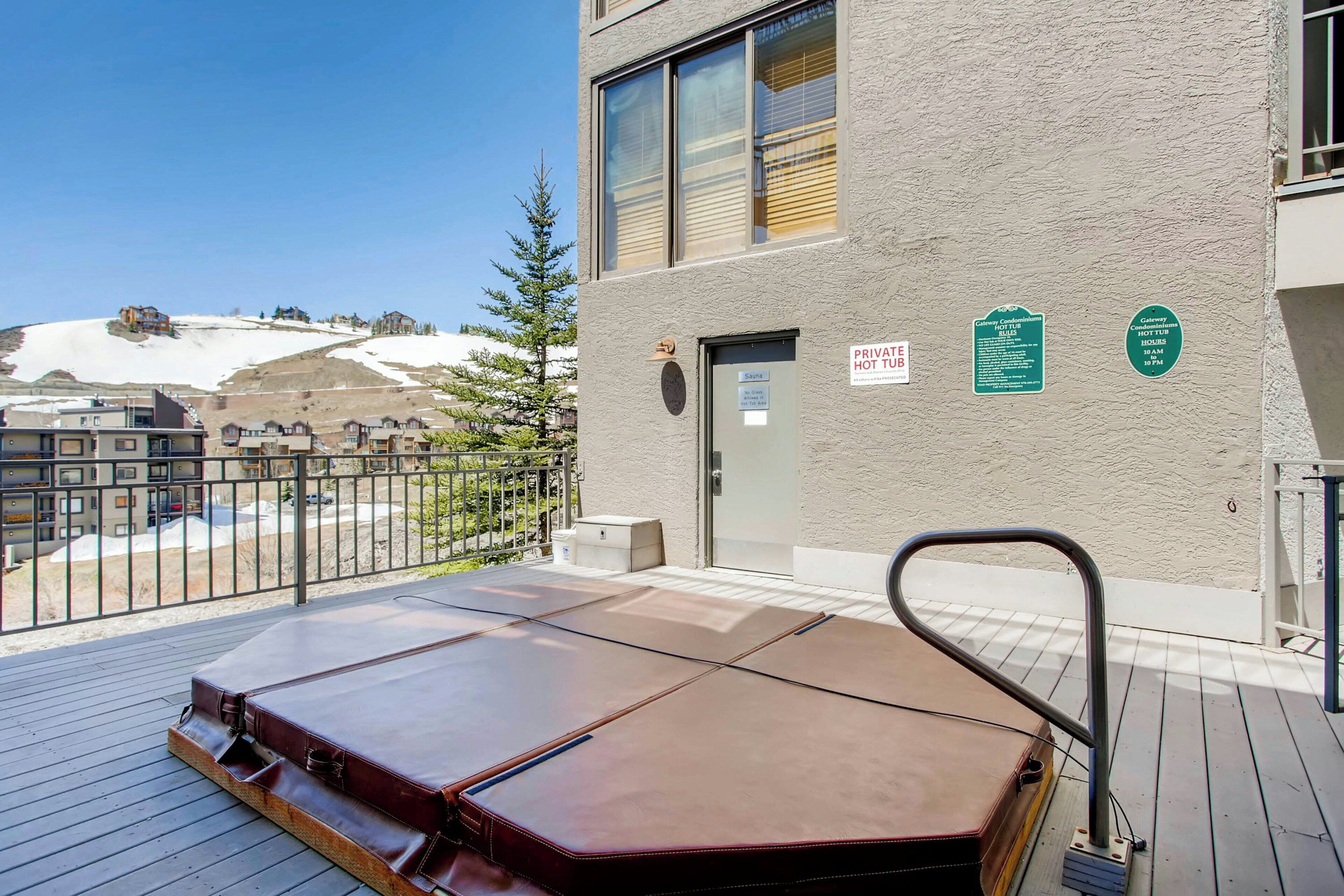 A hotel room with a large bed, a wooden deck, and a view of a snowy landscape.