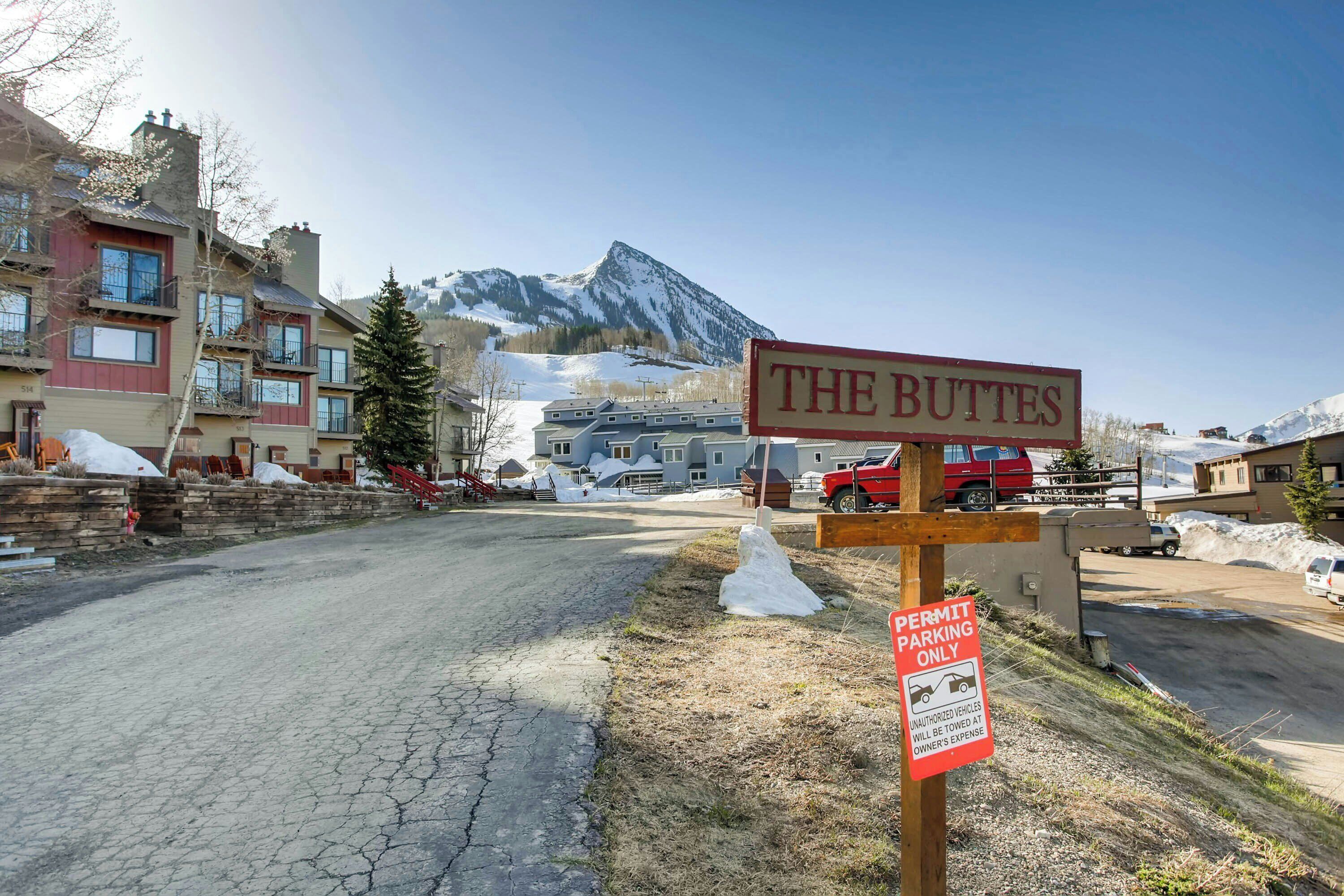 A sign for 'The Buttes' with a parking sign indicating 'Permit Parking Only'.