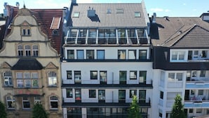 Ein mehrstöckiges Gebäude mit moderner Fassade, großen Fenstern und Balkonen.