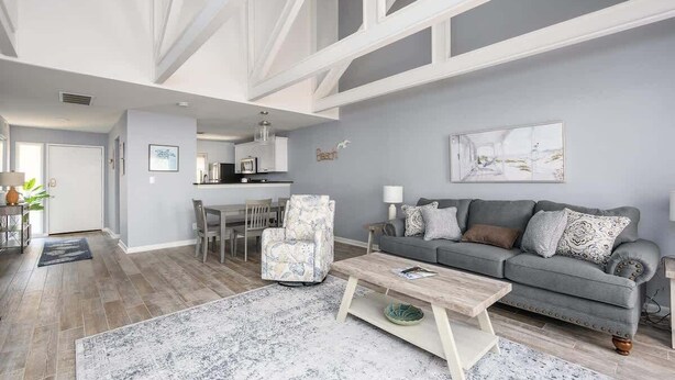 A modern living room with a grey sofa, patterned armchair, and a coffee table.
