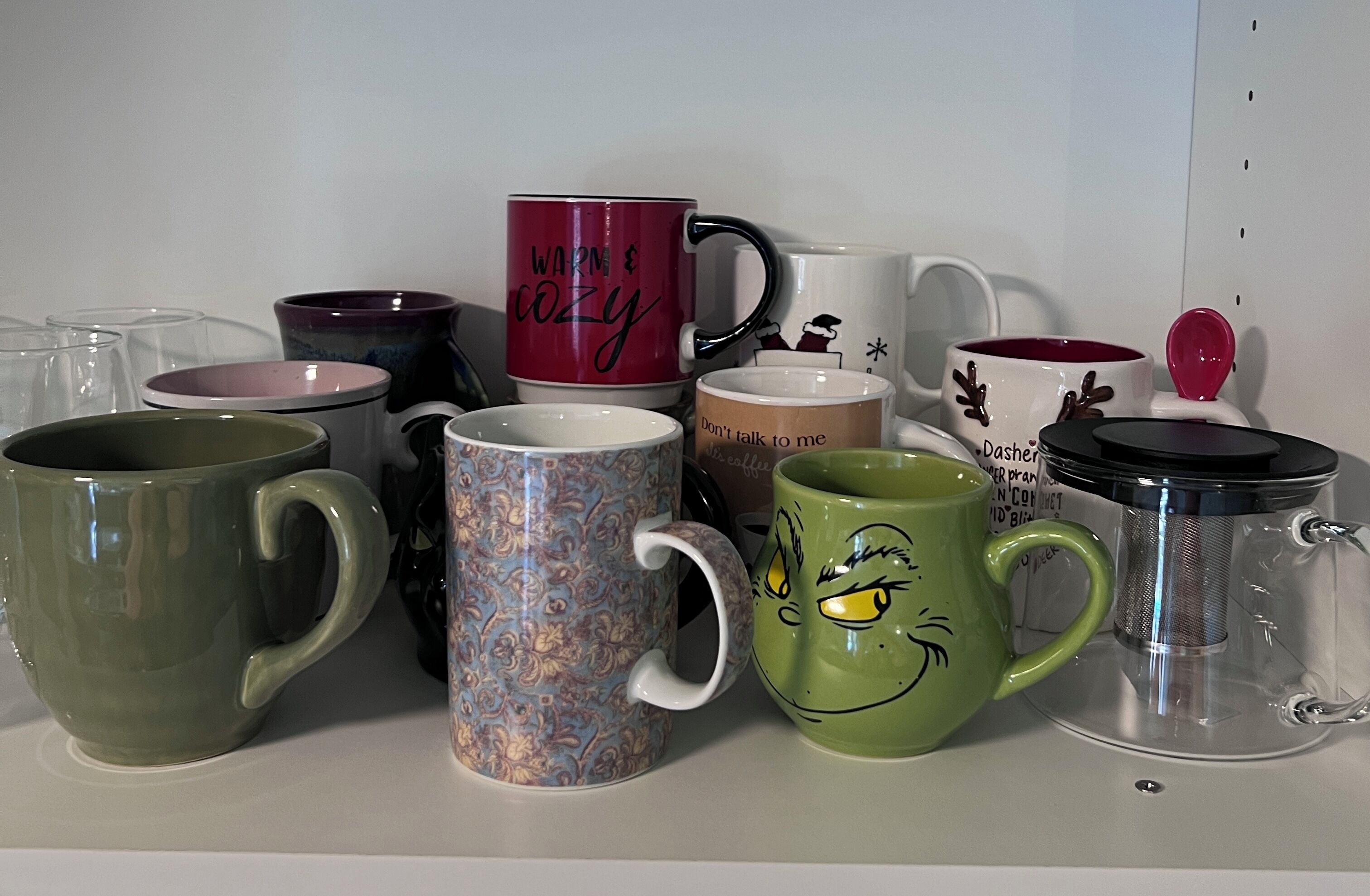 A collection of mugs with various designs and messages, including "warm & cozy" and "Don't talk to me."