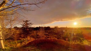 A natural landscape with a hill, trees, and a sunset. - The Cyberhut (Underwood)