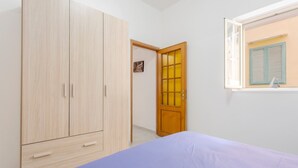 Una camera da letto con un letto, un armadio, una porta e una finestra.