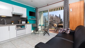 A compact living space with a kitchenette, a dining area, and a sofa. - Apartment 'Bella Mar' with Sea View, Private Terrace and Air Conditioning (L' ESCALA)