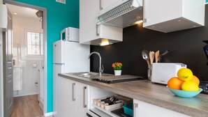A modern kitchen with a sink, a microwave, and a bowl of fruit on the counter. - Apartment 'Bella Mar' with Sea View, Private Terrace and Air Conditioning (L' ESCALA)