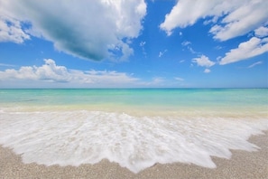 Ein Strand mit klarem türkisblauem Wasser und weißem Sand.