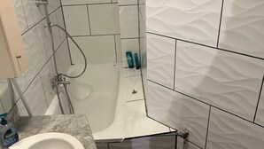 A bathroom with a bathtub, a sink, and a toilet.