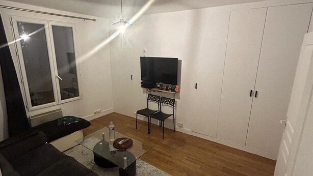 A modern living room with a sofa, a coffee table, a TV, and a cabinet.