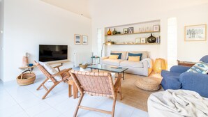 A living room with a TV, sofa, chairs, and a coffee table. - Villa 'Es Tancat' with Sea View, Private Pool and Wi-Fi (Sa Ràpita)