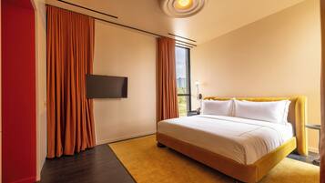Una habitación de hotel moderna con una cama grande, un televisor de pantalla plana y vistas a la ciudad.