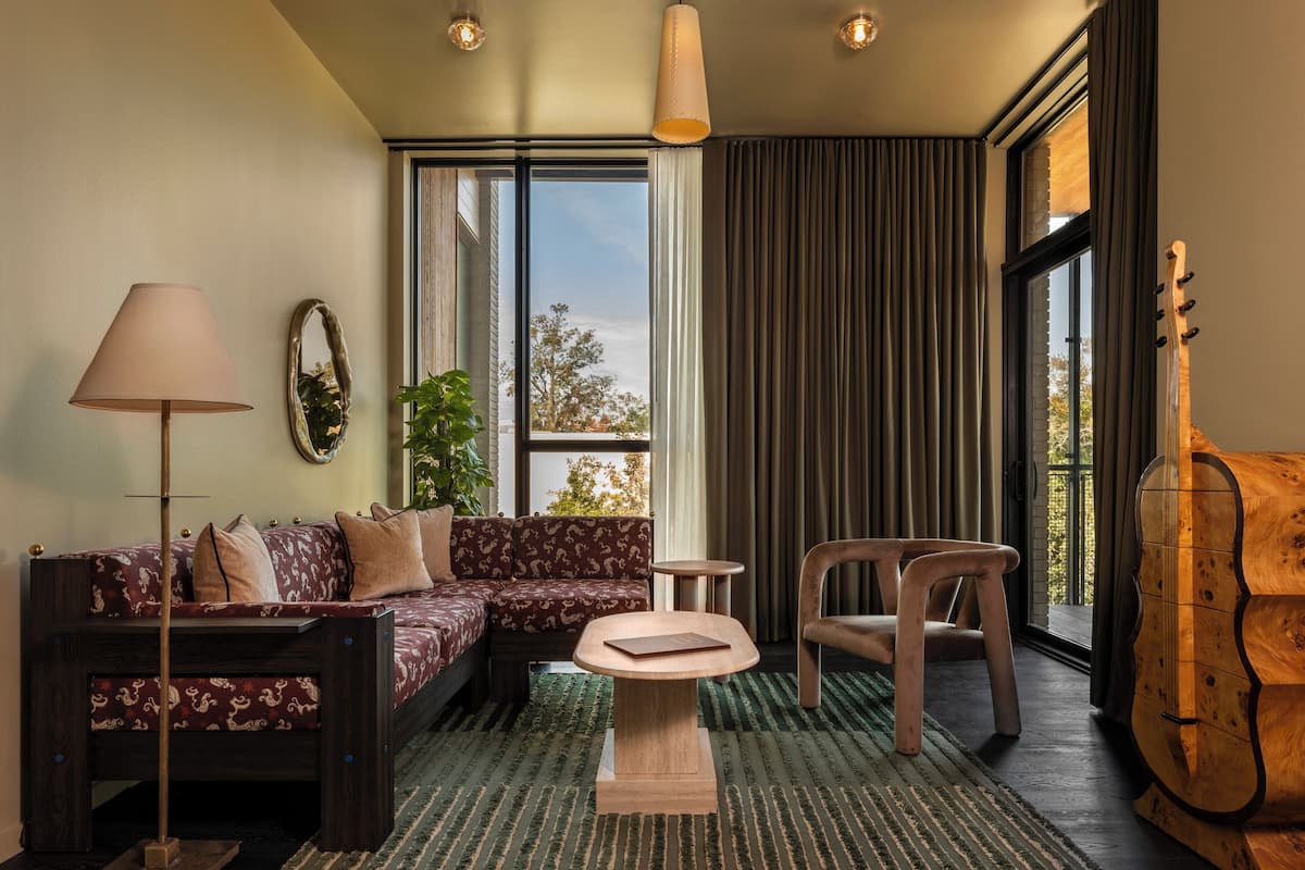 A cozy living room with a sofa, armchair, lamp, and a small table.