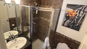 Ein Badezimmer mit Duschkabine, Waschbecken und Toilette.