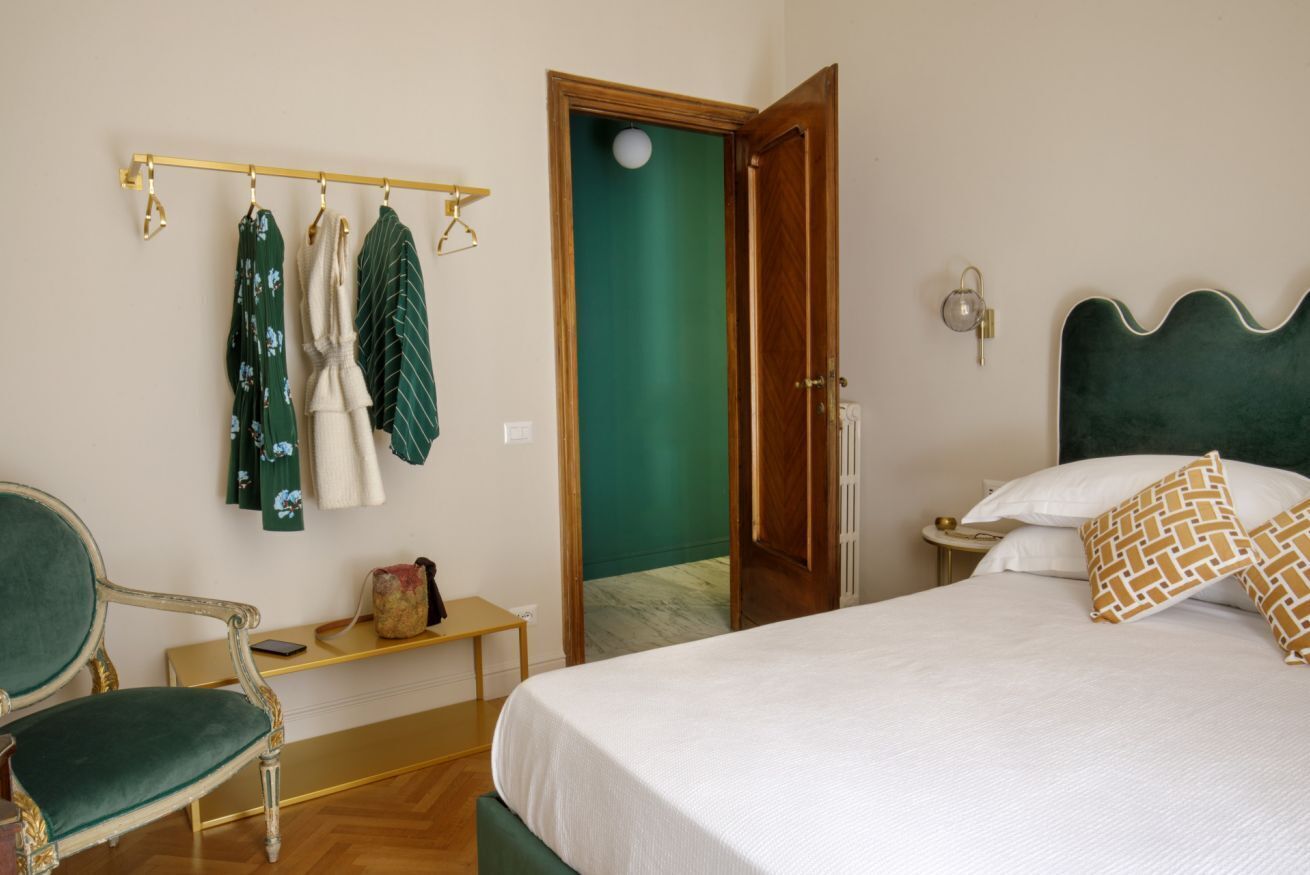 A bedroom with a bed, a chair, a bedside table, and a wardrobe.