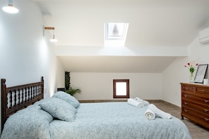 A bedroom with a bed, a dresser, a skylight, and a small window. - La Carbonera – Country House for 8, Ciudad Real, Private Terrace & AC (Alaejos)