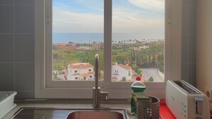 Una cucina con lavello, tostapane e finestra vista su zona residenziale.