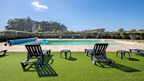 Une piscine avec des chaises longues et une petite piscine gonflable.