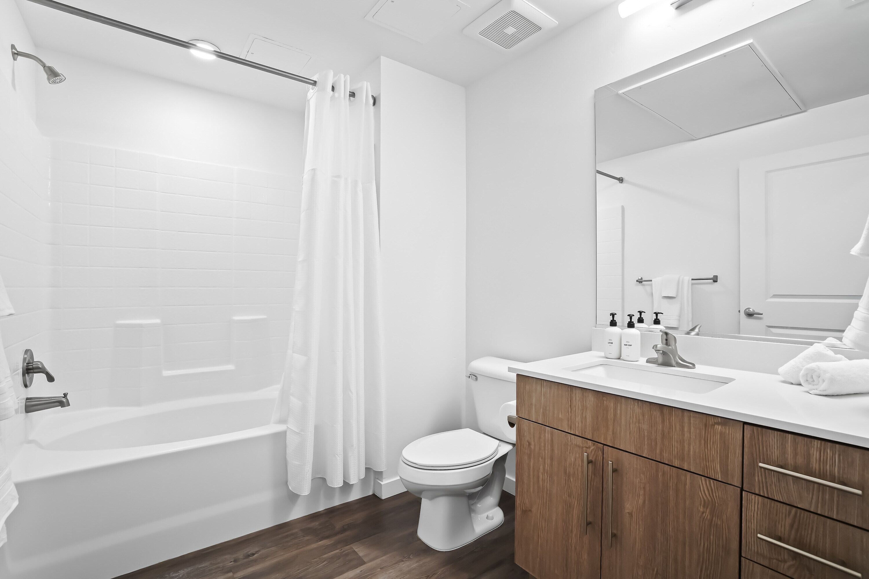 Un baño moderno con bañera, inodoro y tocador de madera.