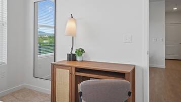 Un espace de bureau moderne comprenant un bureau, une chaise, une lampe et une plante en pot.
