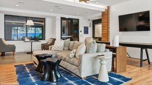 Una sala de estar moderna con un sofá, una mesa de centro y un televisor montado en la pared.