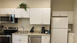 A modern kitchen with white cabinets, stainless steel appliances, and a granite countertop.