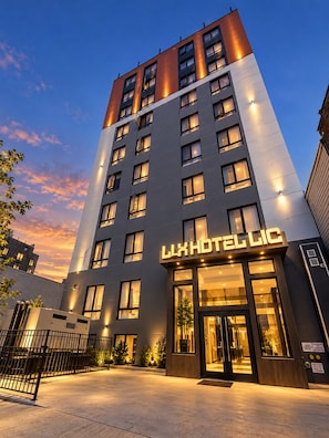 En modern hotellbyggnad med en framträdande entré och upplyst skyltning.