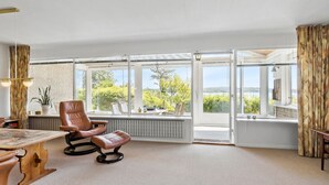 Amplia habitación con ventanas grandes que ofrecen vistas a zonas verdes y colinas.