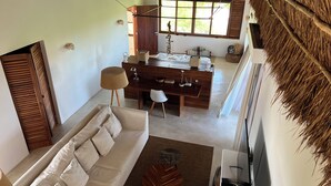 Amplia sala de estar con sofá, mesa de comedor y cocina al fondo.
