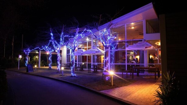 A building with outdoor seating and blue lights. - Brinkley Resort (Methven)