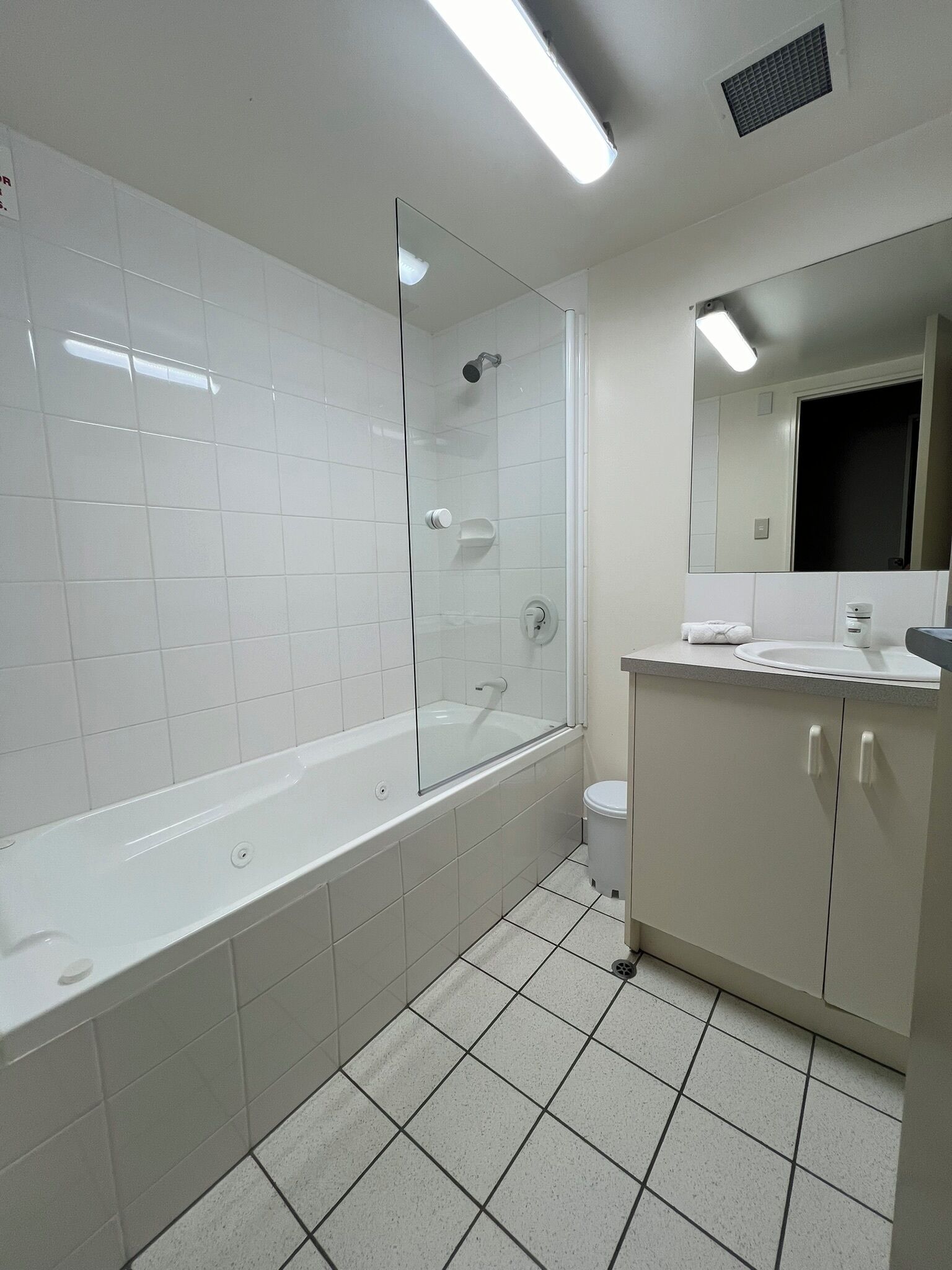 A modern bathroom with a glass-enclosed shower, a standalone bathtub, a toilet, and a vanity with a mirror.
