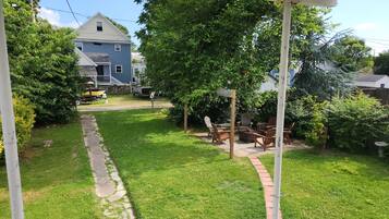 A backyard with a wooden deck, outdoor furniture, and a stone pathway.