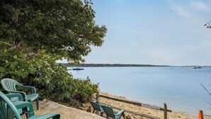A beach with green chairs and a caution sign. - Trendy Great Pond Escape! HotTub Open! Sleeps 9! (Falmouth)