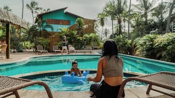 Una piscina al aire libre, sillones reclinables de piscina