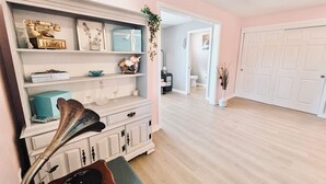 A room with a white cabinet, a blue gift box, and a decorative plant. - Audrey- an ode to an icon (Salem)