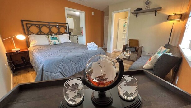 Une chambre d’hôtel avec un lit, une table de chevet, une lampe et un globe décoratif posé sur un plateau.