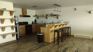 Eine Küche mit Holzausstattung, einer zentralen Kochinsel mit Barhocker und einem Mülleimer.
