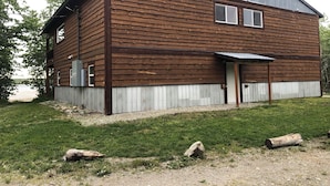 Ein zweistöckiges Holzgebäude mit einem Metall-Dach, einer Haustür und einem kleinen Vorbereich.