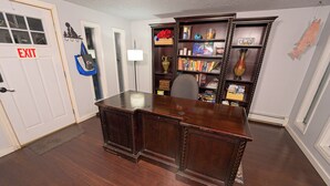 Una habitación con un escritorio de madera, una estantería y una señal de salida.