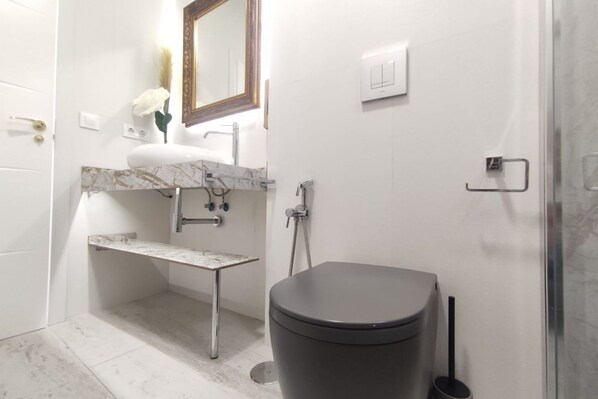 A bathroom with a toilet, sink, and shower.