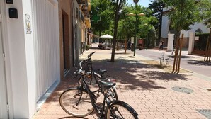 A brick-paved sidewalk with two bicycles parked against a building. - The Urban Elegnace Suite (Sevilla)