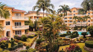 A resort with multiple two-story buildings, a central pool area, and well-maintained gardens with various plants and flowers. - Paradise On Earth  (Boca Chica)