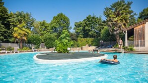 A swimming pool with lounge chairs and palm trees.