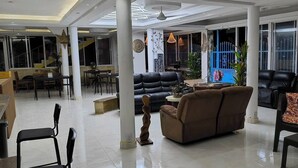 A spacious living area with a sofa, chairs, and a dining table. - Hotel Condo Mango (Boca Chica)