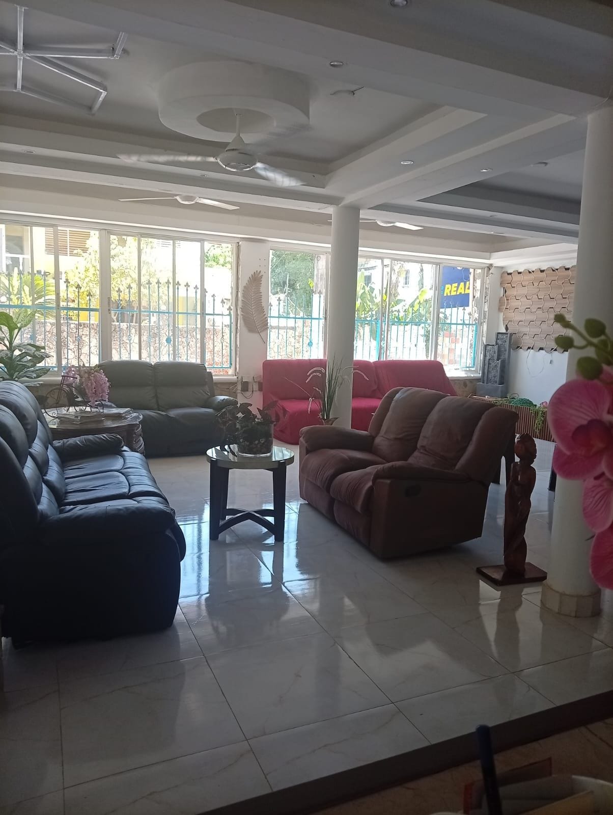 A spacious living area with a large sofa set, a coffee table, and a decorative plant.