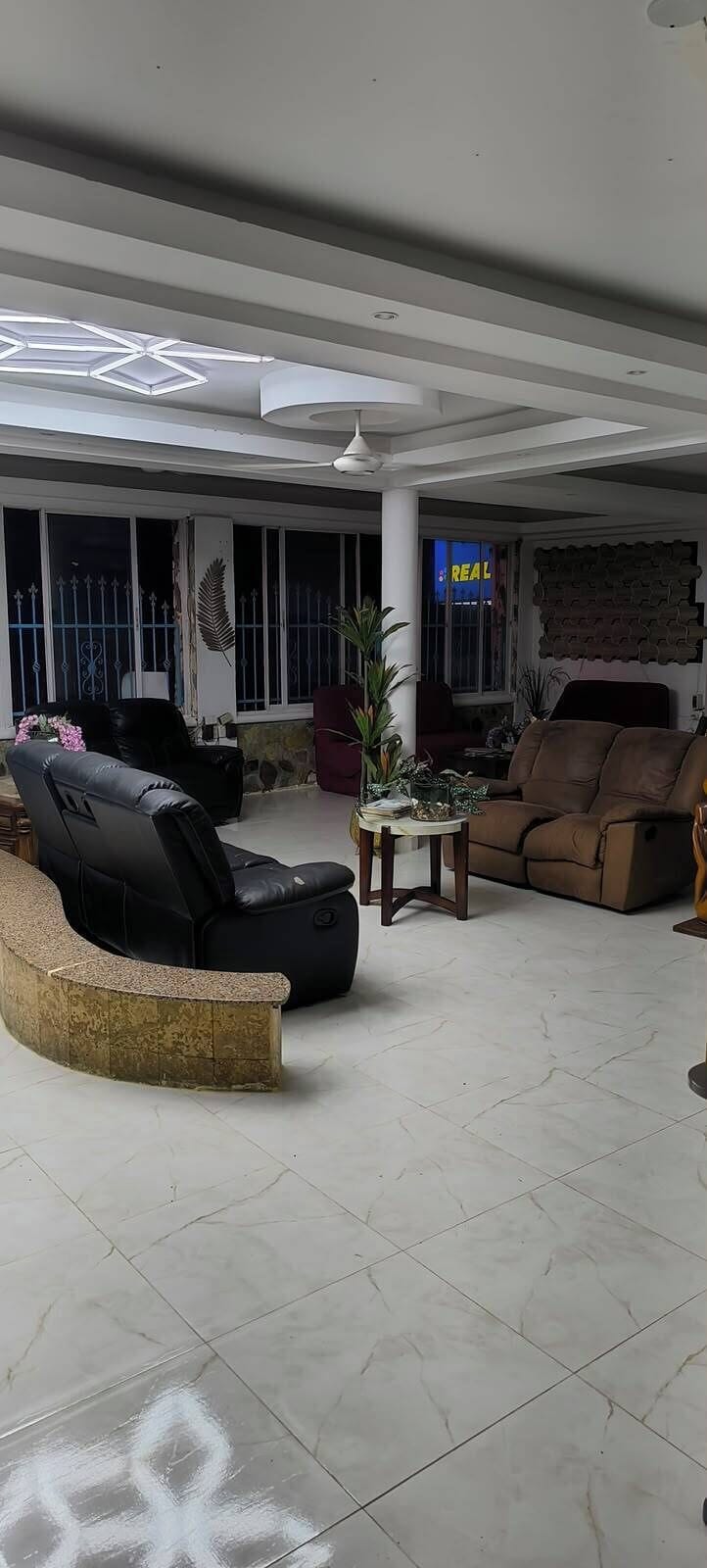 A spacious living area with a curved seating arrangement, a coffee table, and a television.