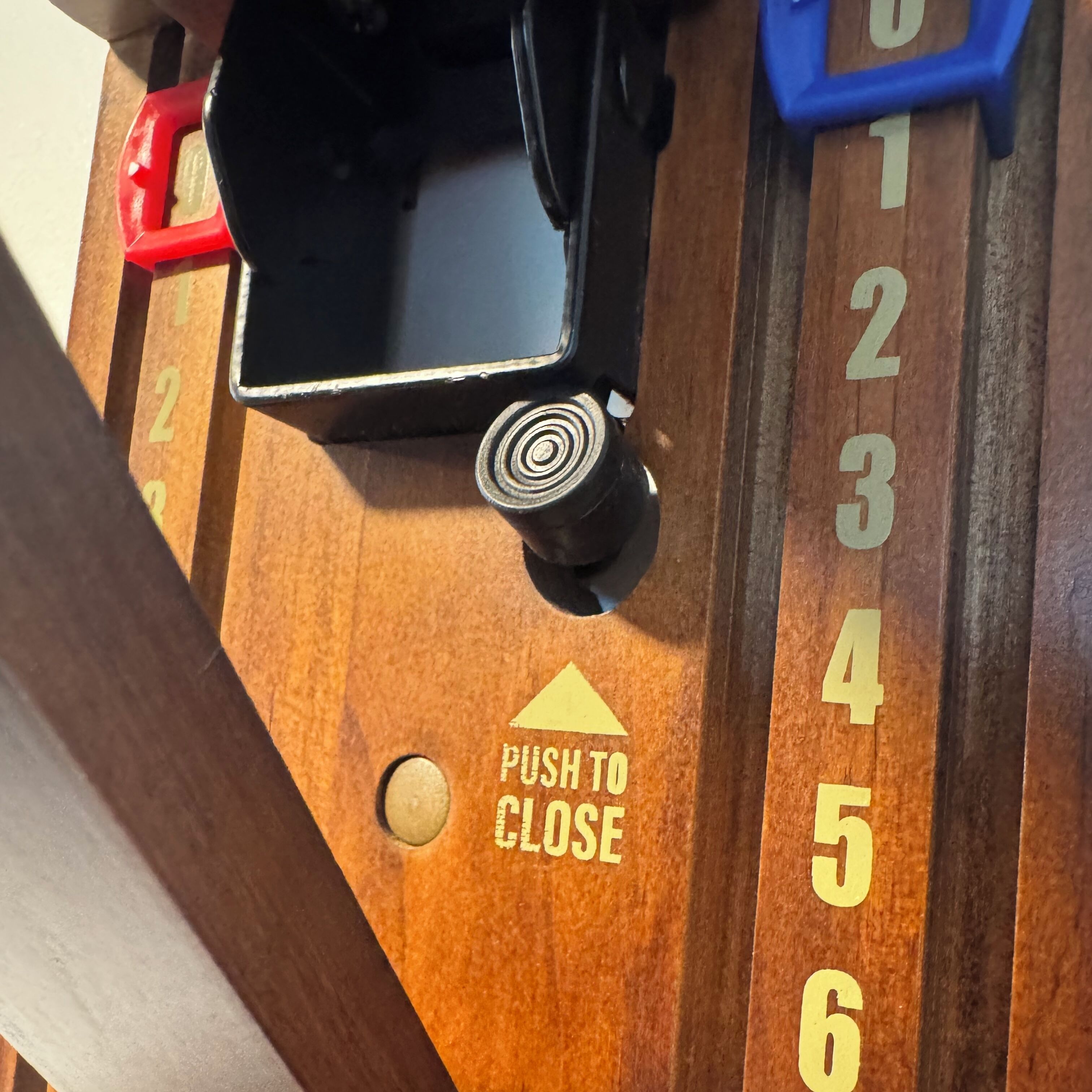 Een houten paneel met genummerde vakken en een sluitmechanisme.