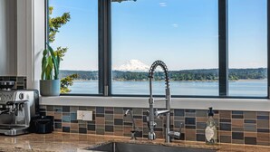 A kitchen with a view of a lake and a mountain. - Puget Sound Waterfront | Eagles, Orcas & Mt. Rainier Views (Gig Harbor)