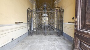 A hallway with a wrought iron gate leading to a room.