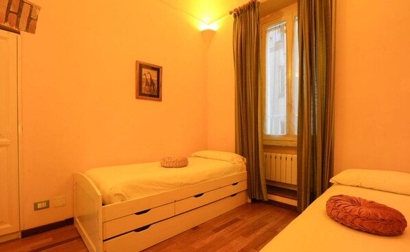 A small, bright room with a single bed, a nightstand, and a window with curtains. - Roma, Castelfidardo House (Roma)